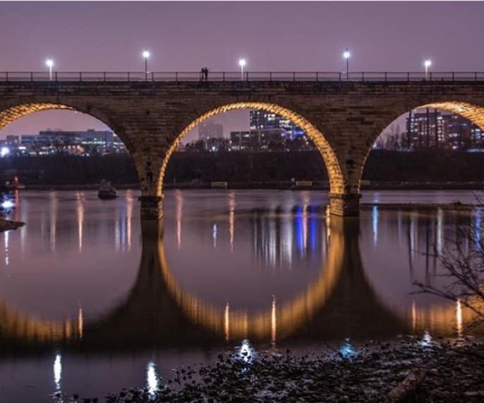 Stone Arch Bridge at night reflected into the Mississippi River