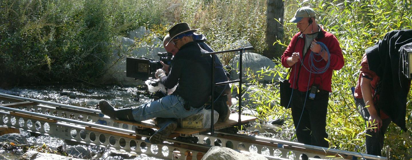 A film crew with a camera on a track, filming something. 