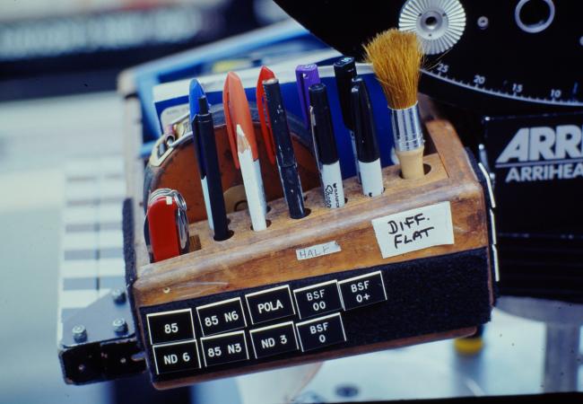 Pocketknife, pens, pencils, brushes and sharpies attached to the side of an arri camera