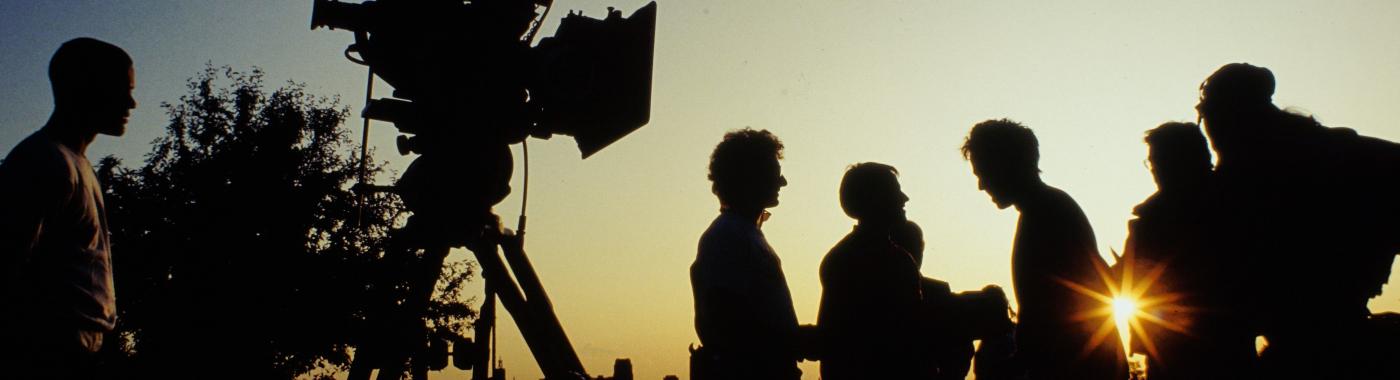Crew and camera in silhouette against sunset
